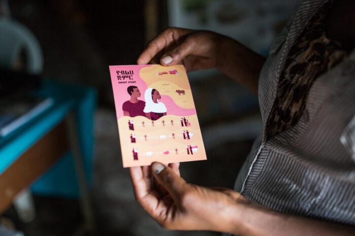 A health extension worker at Alem Ber Zuria health post holds a contextualized "Smart Start" information tool used to sensitize adolescent girls and couples about family planning and contraception in Fogera District, Amhara, Ethiopia on November 8, 2019.