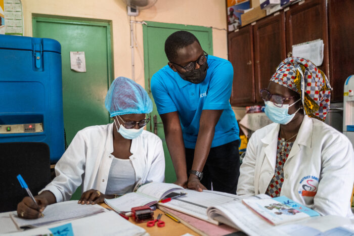 From left to right, Awa Cisse, a student in biology-nutrition and intern, Massamba Fall, a multimedia digital communication assistant and member of the UNICEF team, and nurse, Binette Thiaw discuss immunization protocol at the Philippe Maguilen Senghor Hospital in Dakar, Senegal on August 25, 2021.